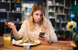 woman eating and texting