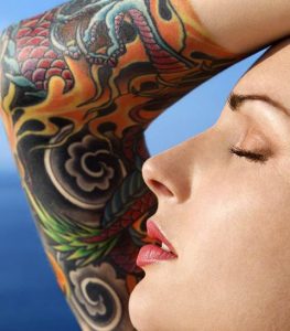 woman with tattoo sunbathes