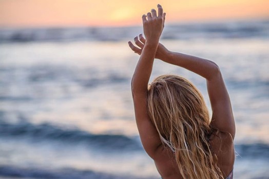 γυναίκα θάλασσα σηκώνει χέρια προστατεύσεις ξανθά μαλλιά καλοκαίρι