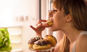 γυναίκα τρώει donuts