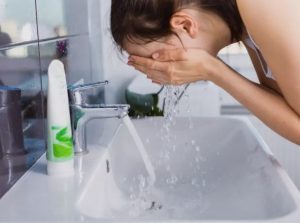 γυναίκα πλένει το πρόσωπο της