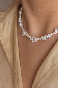 κοπέλα φορά λευκό κολιέ με πέρλες καλοκαιρινά κοσμήματα